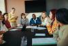 A group of university students sitting around a table having a discussion