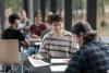 University students sitting at a table discussing a project