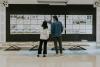 Architecture students inspecting plans on a board